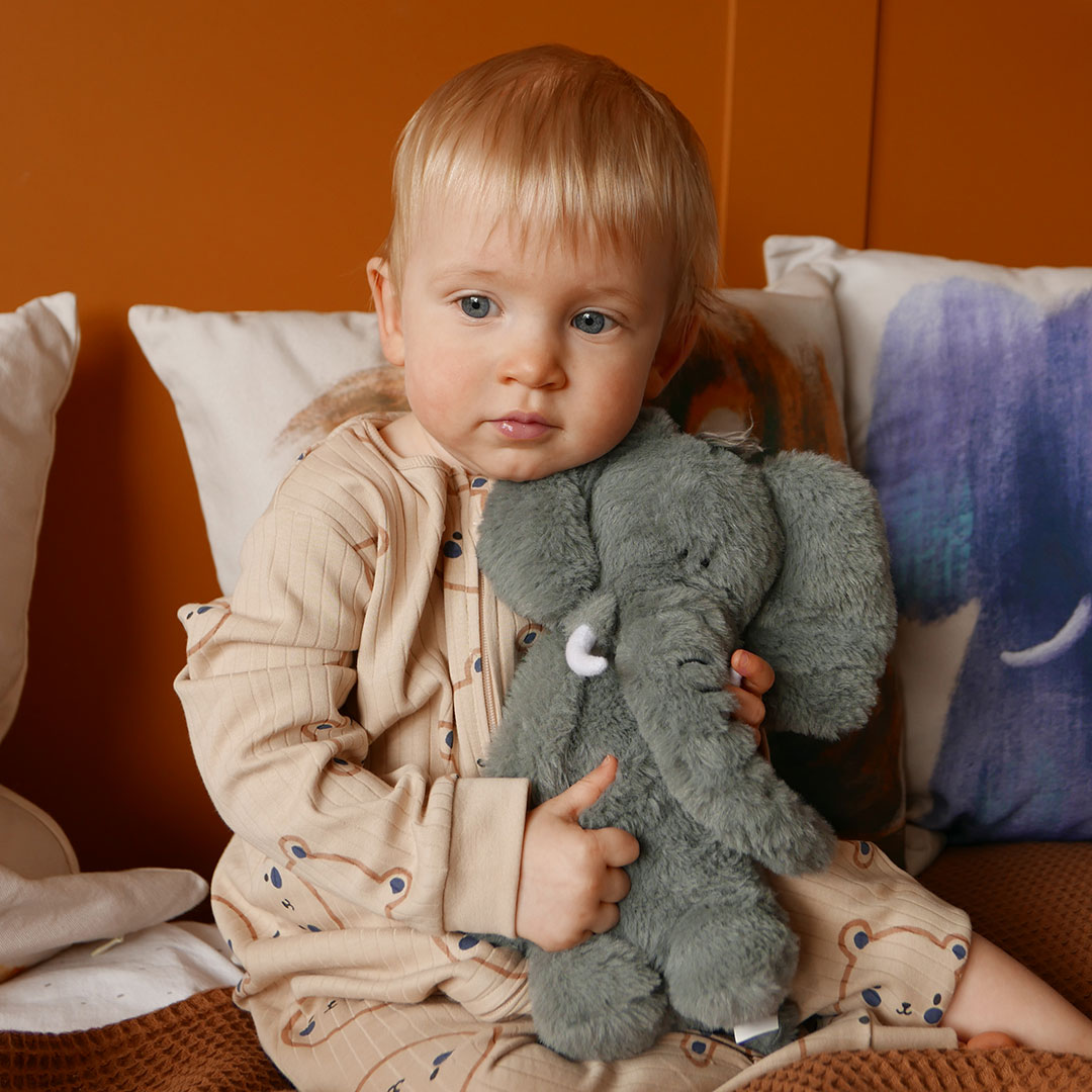 Cute baby cuddling elephant soft toy