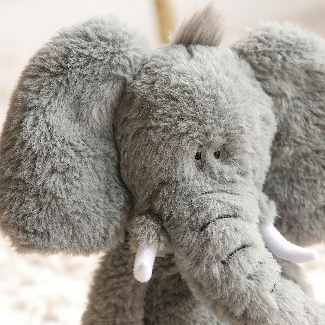 Close up showing cute face and plush tusks of elephant soft toy